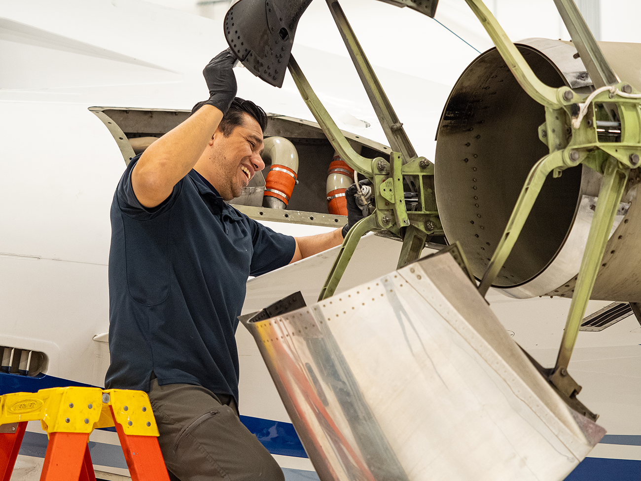 flyExclusive technician working on an aircraft in the hangar