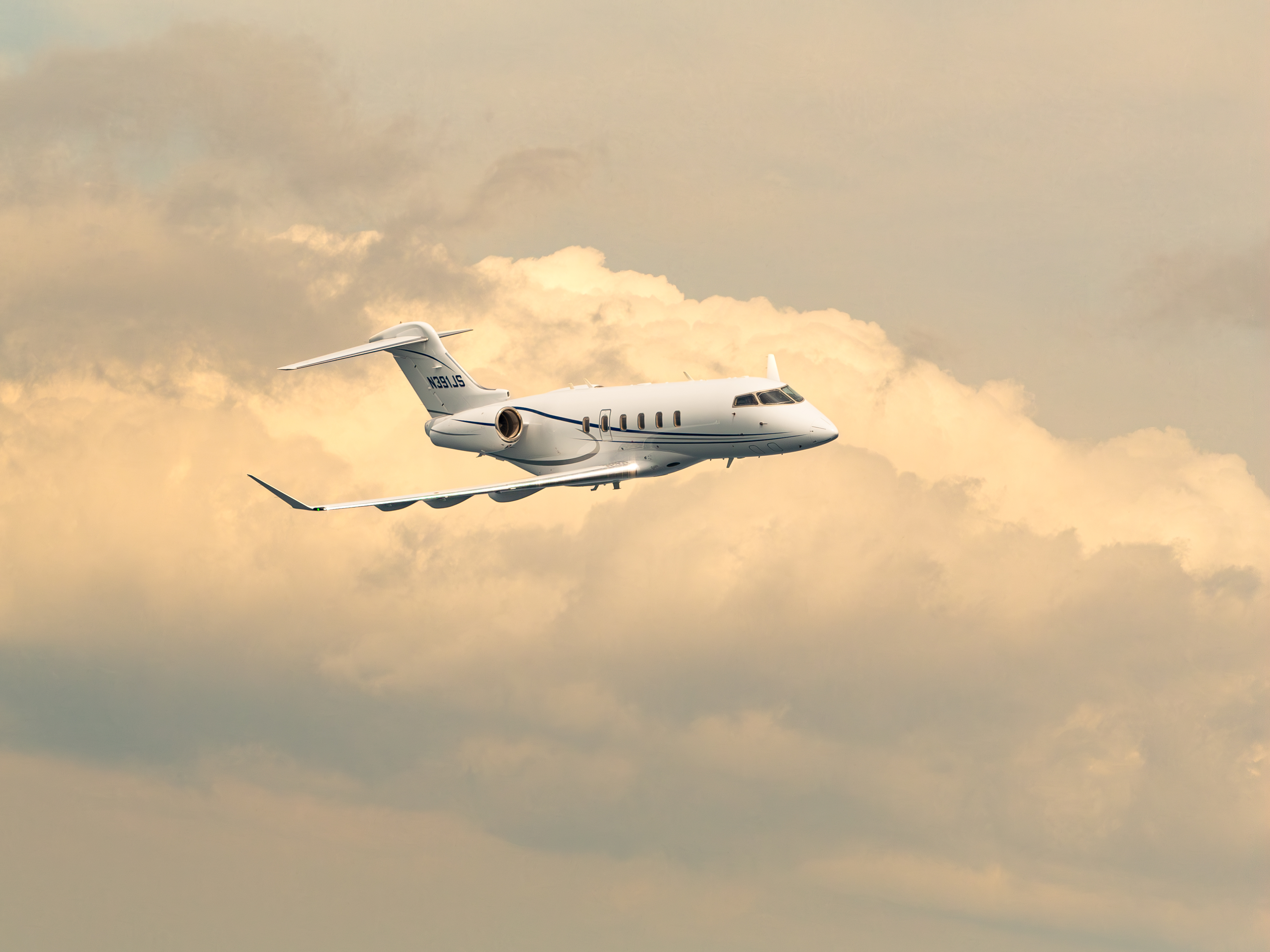 flyExclusive Challenger 350 air-to-air at golden hour