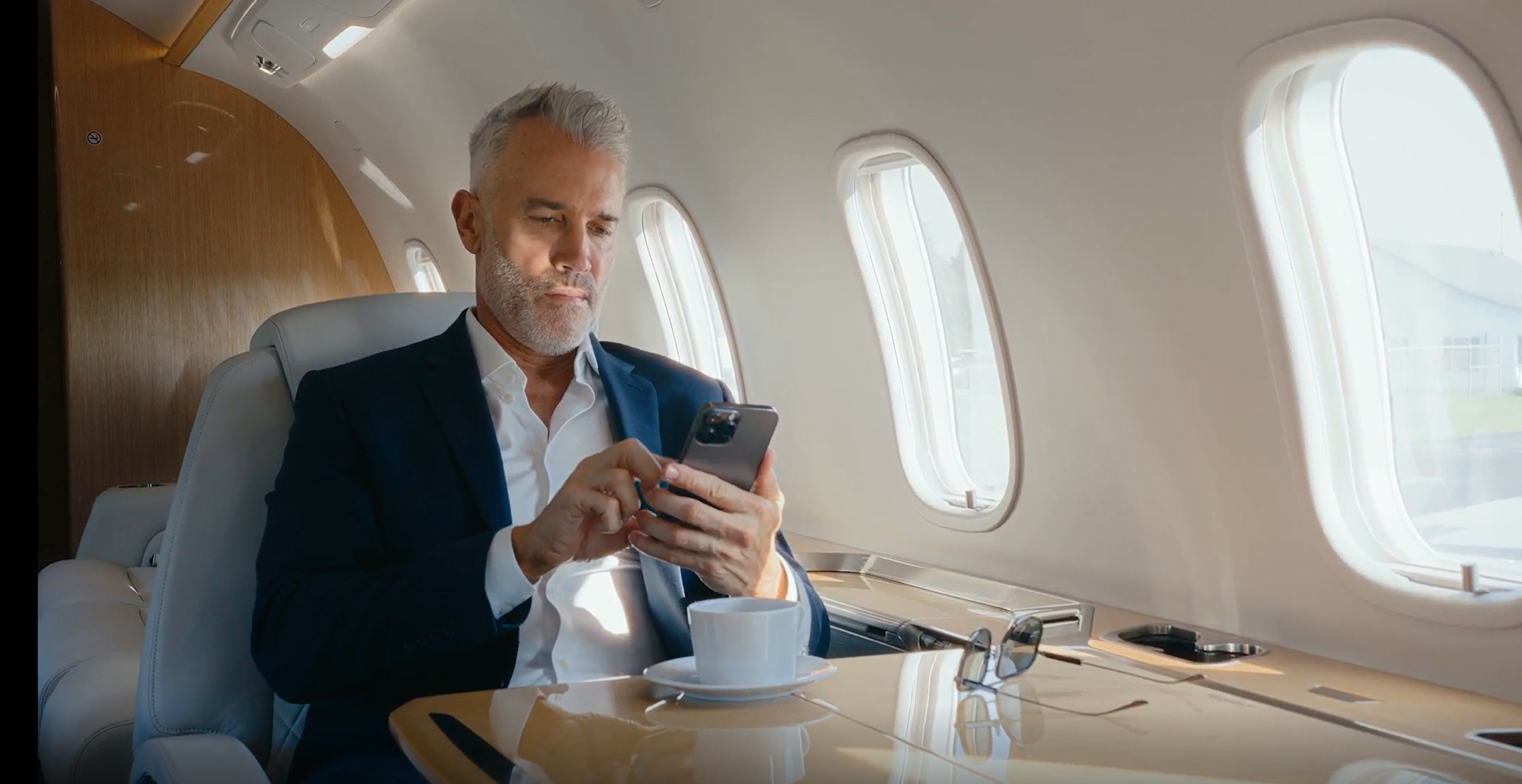 A member managing their trip on the flyExclusive app from the cabin