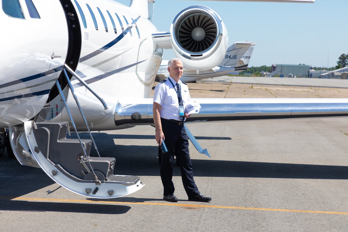 flyExclusive W-2 captain at the airstairs of a Challenger 350