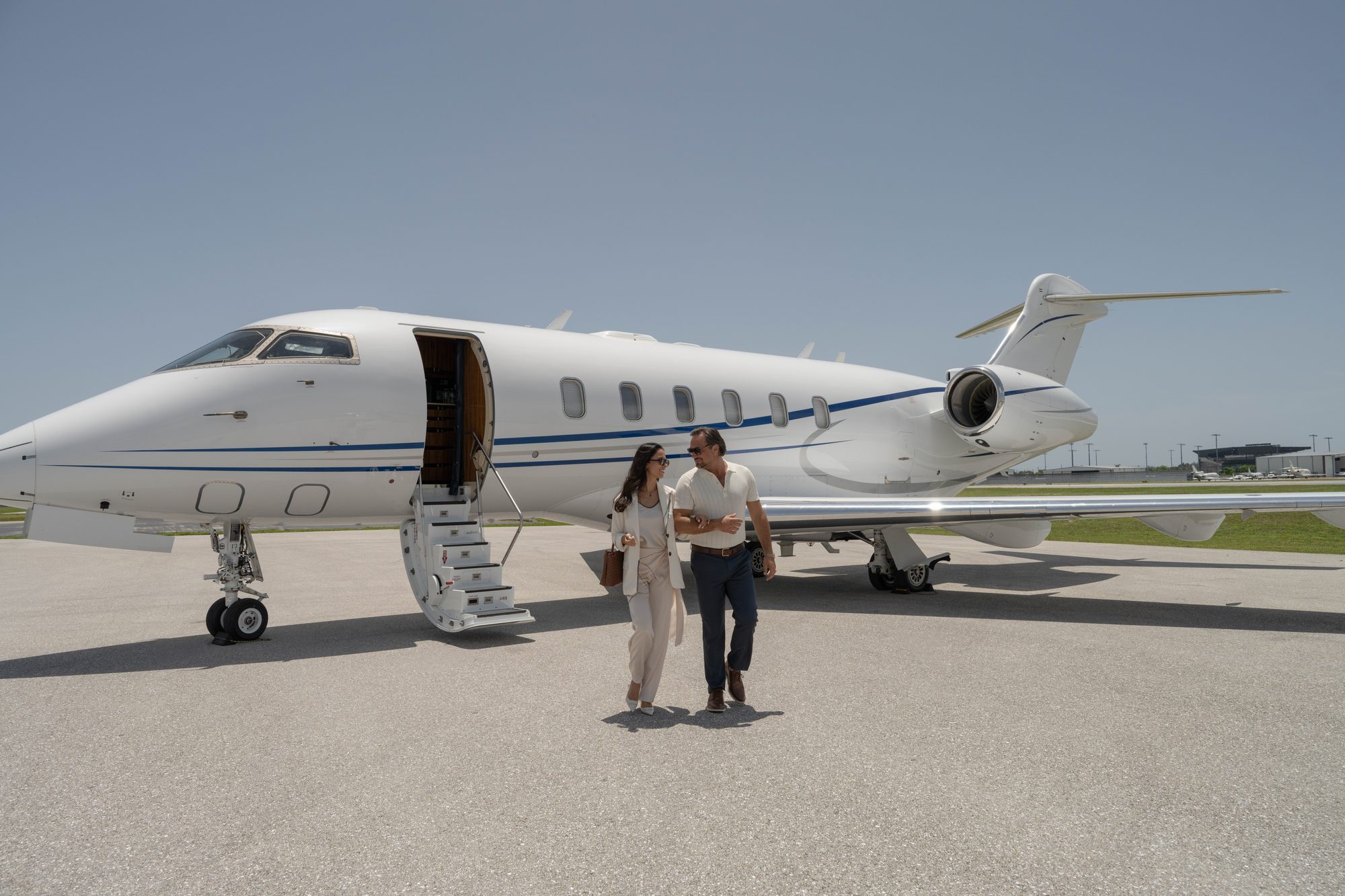 Two members walking from the airstairs of a flyExclusive Challenger 350