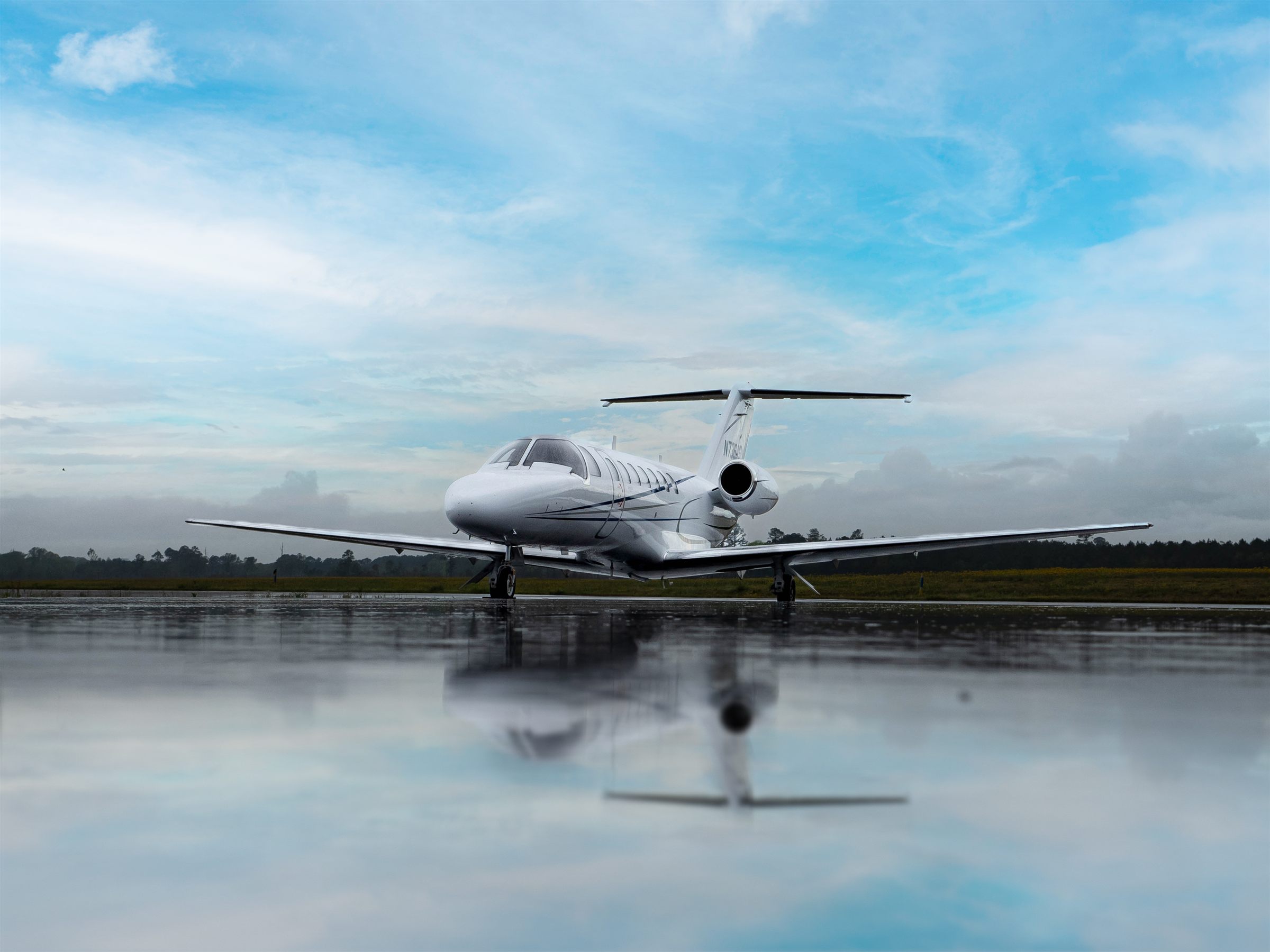 A flyExclusive Citation CJ3+ on a mirror-still lake ramp