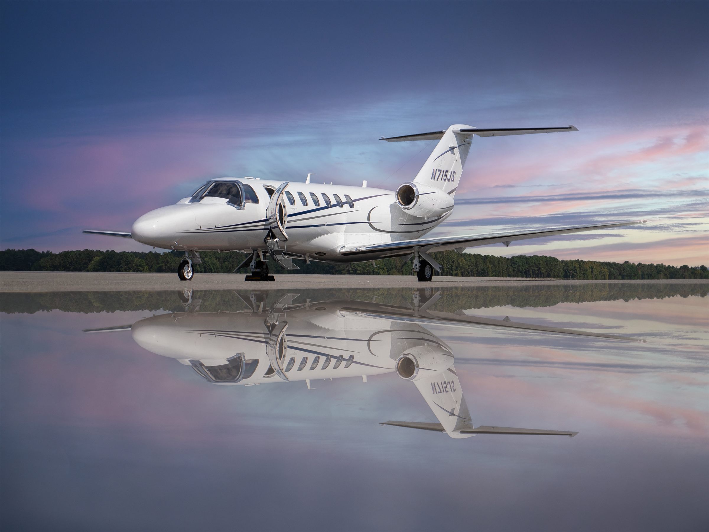 Citation CJ3+ reflected on wet pavement at dusk