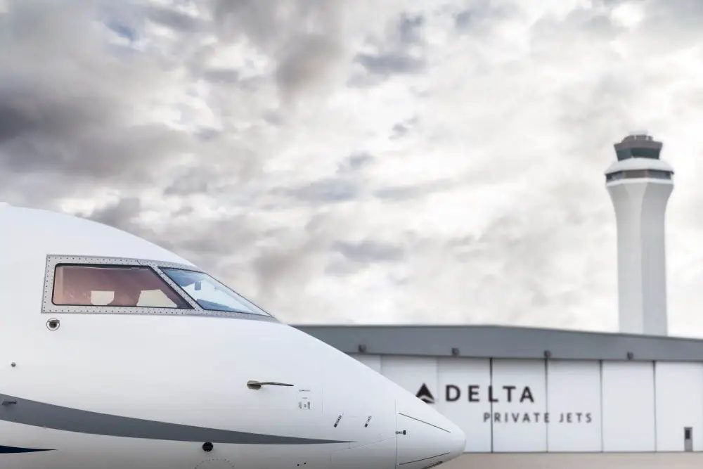 A private jet on the ramp outside a Delta Private Jets hangar