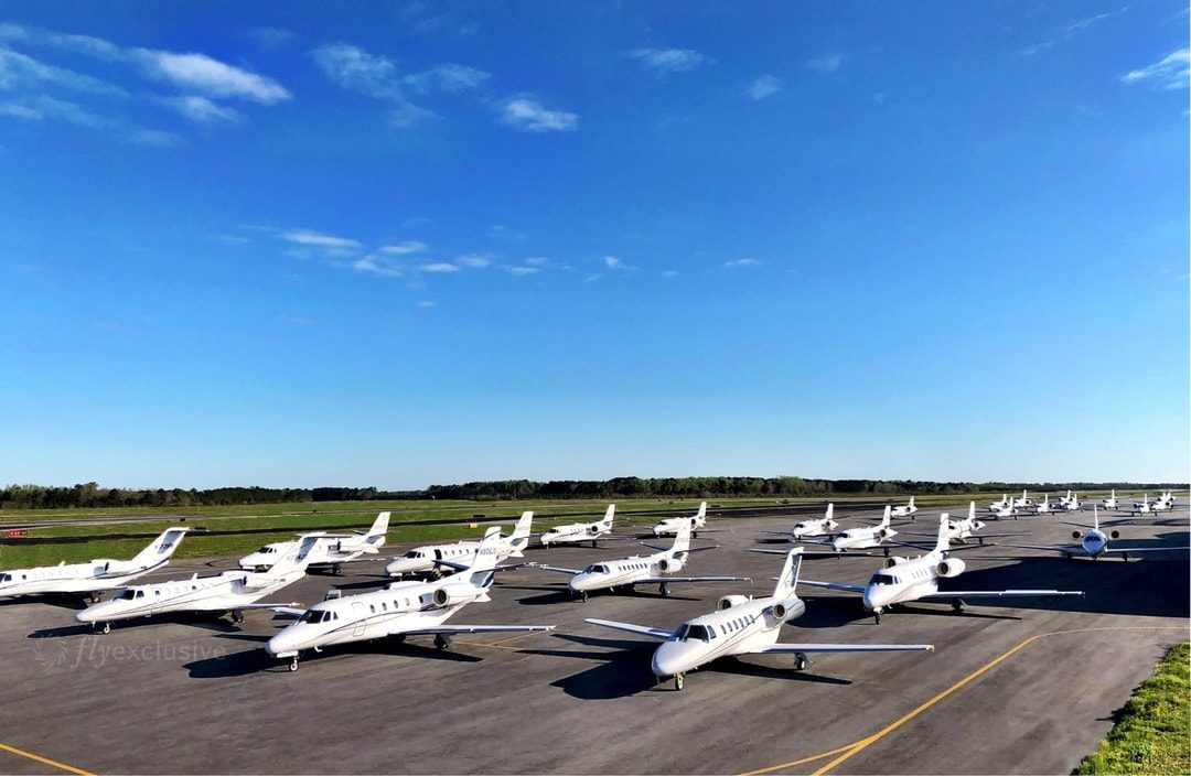 A line of flyExclusive Citations parked along the ramp