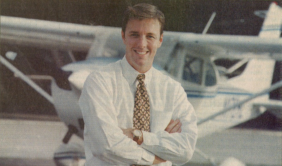 Newspaper photo of a young Jim Segrave in front of a light aircraft