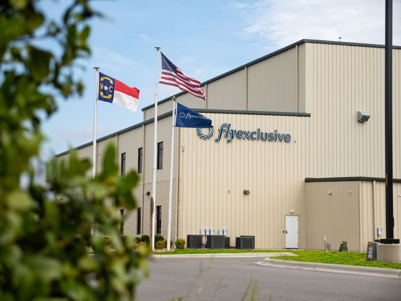 The flyExclusive headquarters in Kinston, North Carolina, with the state and national flags flying outside